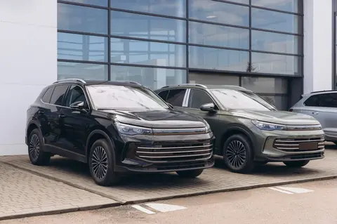 Deux SUV garés devant un bâtiment vitré