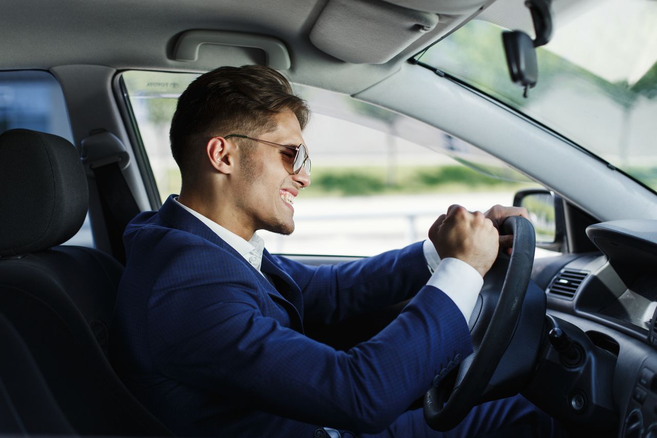 Commercial en costume au volant de sa voiture