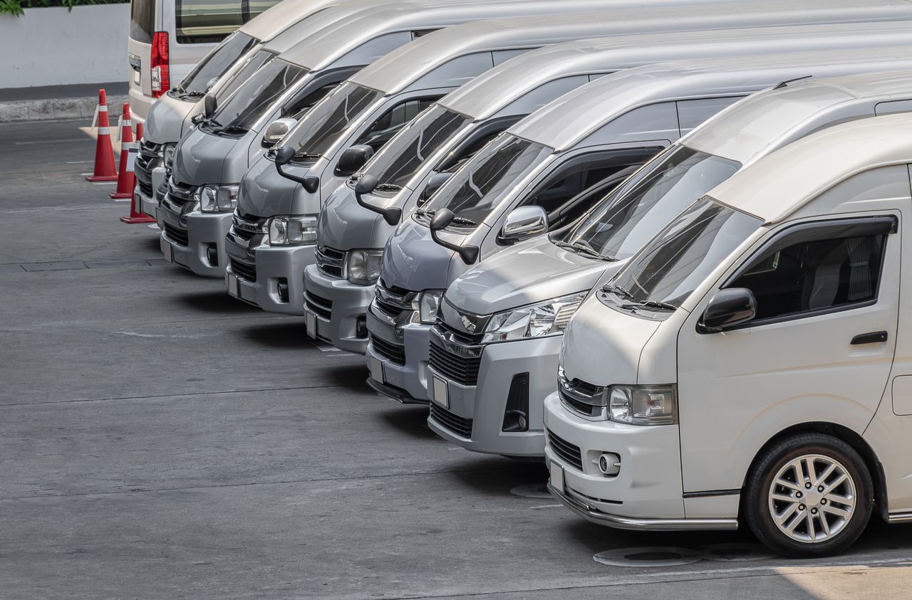 Rangée de fourgons utilitaires blancs garés sur un parking