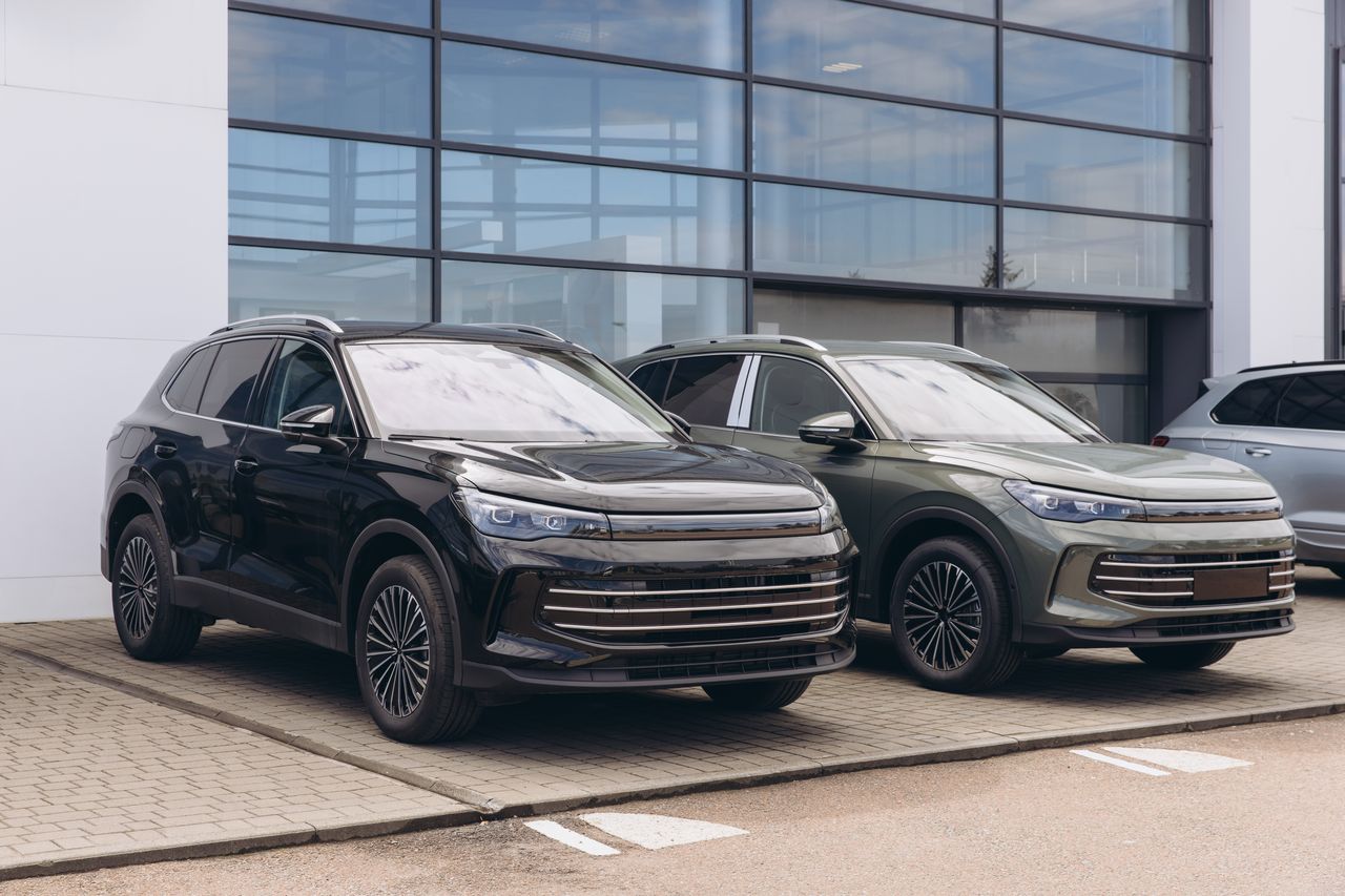Deux SUV garés devant un bâtiment vitré